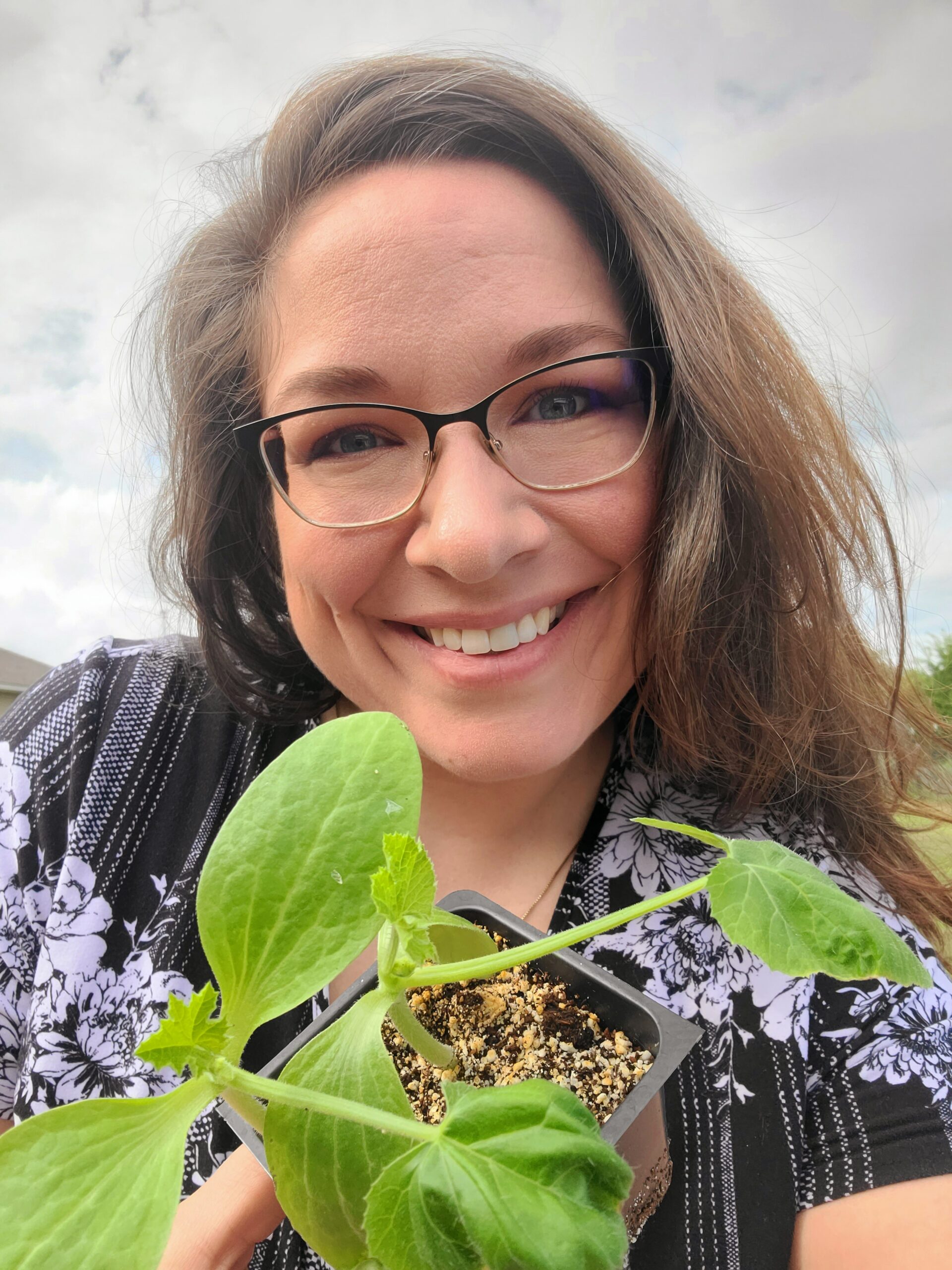 Photo of Stephanie Brown with a seedling plant
