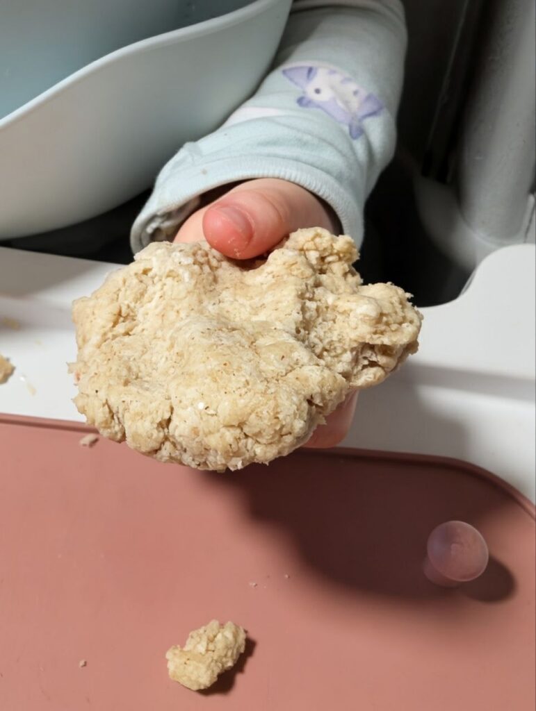 Toddler holding edible dough