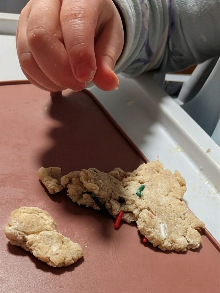 Toddler pinching sprinkles from edible dough